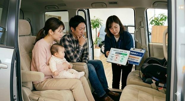 ミニバンの車内で家族がスタッフから信用回復ローンと自社ローンの違いについて比較表を見ながら説明を受けている納得のシーン